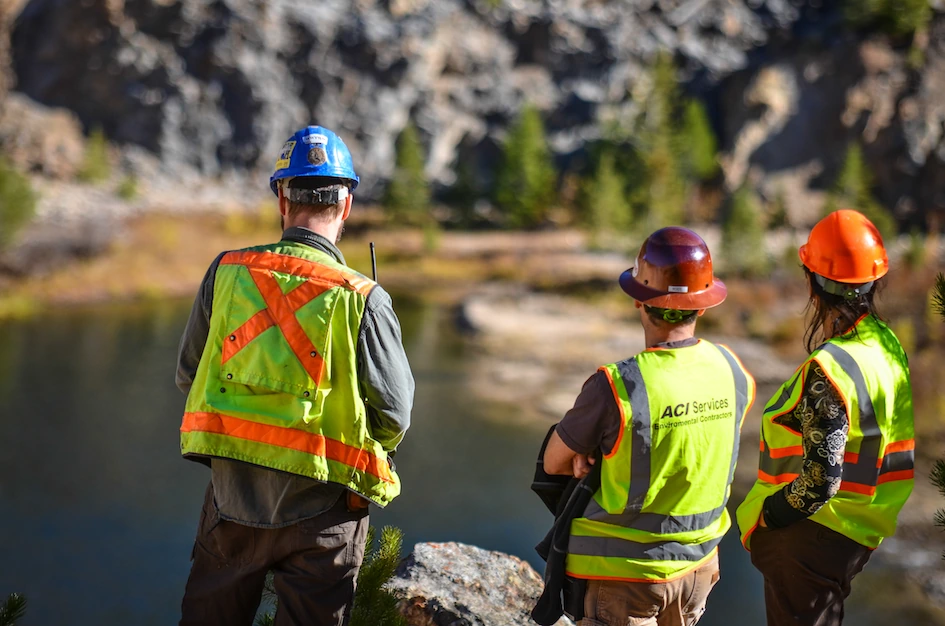 Field workers overlooking a pond
